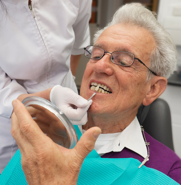 Patienten och tandläkaren gör tillsammans ett färgval för en krona.